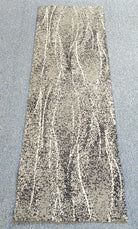Abstract runner rug with beige base and vertical distressed stripe pattern