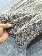 Close-up abstract runner rug texture in navy and light speckled fibers