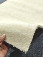 Beige runner rug corner with soft shag texture and short fringe