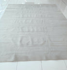 Large oatmeal-beige area rug with mottled soft pile texture