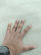 Oatmeal-beige rug surface with dense pile texture; hand pressing fabric