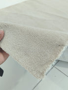 Oatmeal beige runner rug corner detail, dense short pile surface
