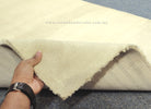 Cream runner rug with hand lifting to show thick pile and raw border