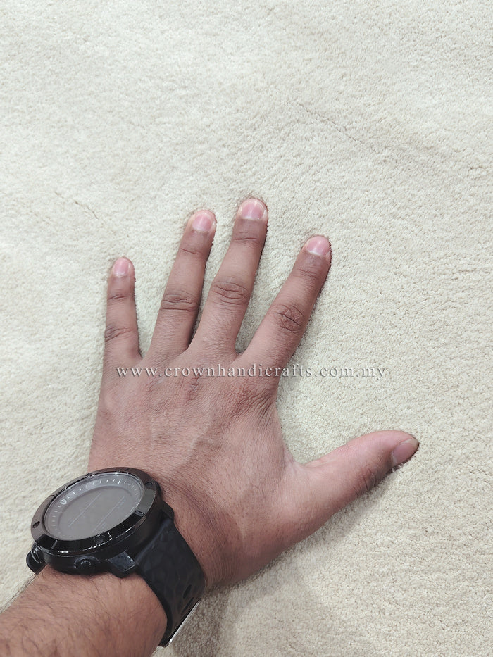 Cream textured rug surface with short shag pile, hand showing soft fibers
