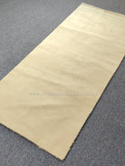 Oatmeal-beige runner rug laid flat with clean border and even, short pile