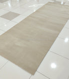 Large cream area rug flat-lay on tile with low, even pile
