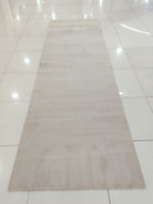 Oatmeal beige runner rug, full view with low pile and short fringe detailing.