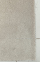 Oatmeal beige runner rug with short fringe along one edge, close-up texture view.