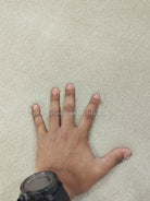 Oatmeal beige runner rug with dense low pile; hand pressing the surface for texture.
