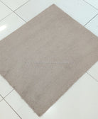 Soft brown fluffy shag rug, single square corner view on tiled floor
