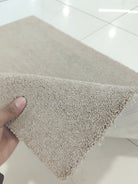 Soft brown fluffy shag rug corner with dense shag pile texture, shown close-up