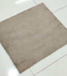 Soft shaggy accent rug with dense short pile, taupe brown square, diagonal angle