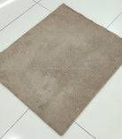 Rectangular shaggy rug in light brown, flat top with low pile texture.