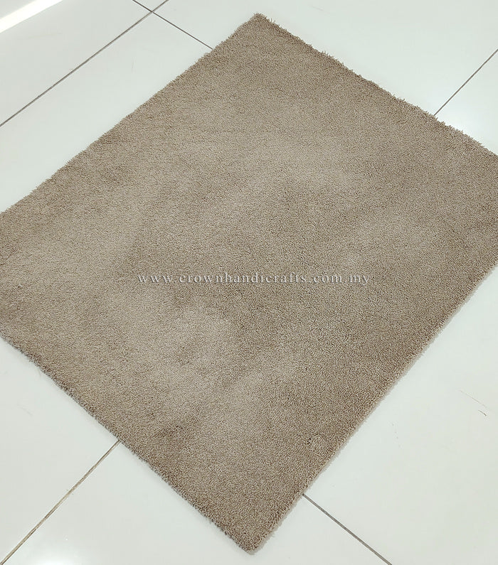 Rectangular shaggy rug in light brown, flat top with low pile texture.