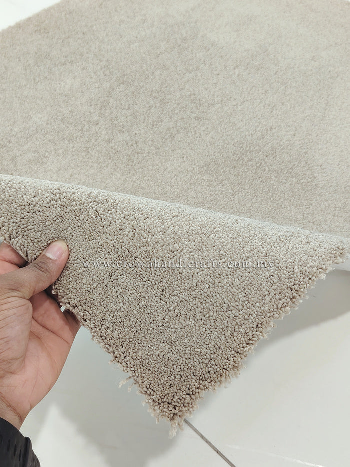 Shaggy rectangular rug, light brown; close view of soft pile with corner edge lifted.