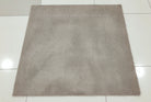 Light brown square rug with short dense pile, laid flat on tiled floor