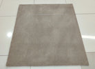 Light brown square low-pile rug, smooth even surface laid flat