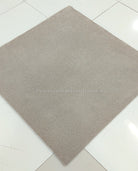Light brown square area rug with short, dense low-pile texture