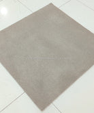 Light brown square low-pile rug with even surface texture