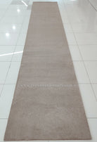 Taupe long shaggy runner rug, full length view on smooth tile