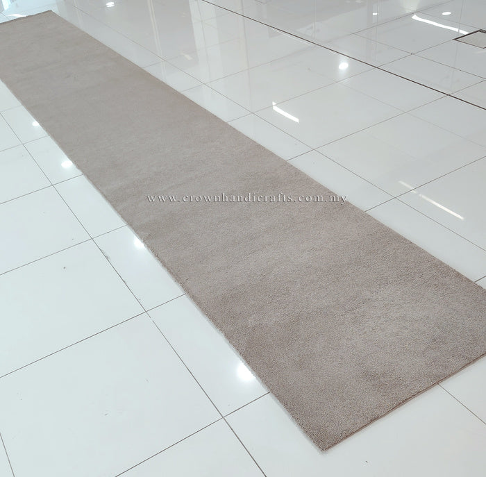 Taupe long shaggy runner rug with low pile, shown from above on tile floor