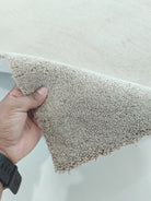 Taupe shaggy runner rug close-up showing dense short pile and trimmed side edge