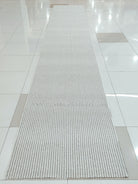 Natural runner rug on floor, long narrow rectangle with looped texture