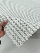 Natural runner rug close-up, ivory and taupe striped loops with fringed trim