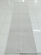 Natural-tone woven runner carpet with dense grid weave, laid flat on floor