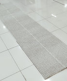 Natural-tone woven runner carpet with tight flat weave and straight stitched edge