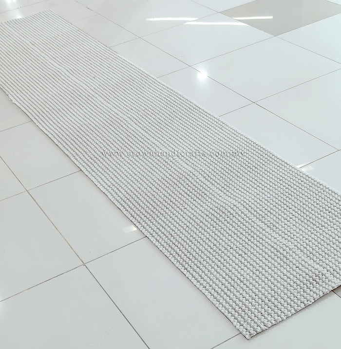 Natural-tone woven runner carpet, tight flat texture with neat straight edge