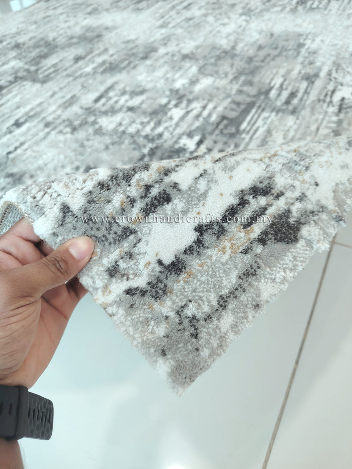 Grey and cream abstract area rug edge, worn distressed motif