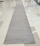 Grey long runner rug with muted mottled look and soft low pile.