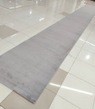 Grey long runner rug with muted mottled pattern and smooth low pile.