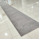 Grey long runner rug with subtle mottled finish and low, soft pile.