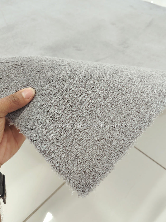 Grey shaggy floor rug corner, dense soft pile with neatly trimmed edge.