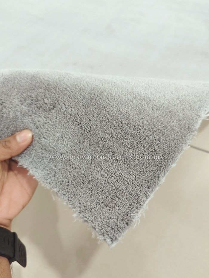 Grey shaggy floor rug corner, soft dense pile with trimmed edge.