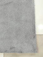 Grey floor rug with fine, speckled texture and smooth short pile.