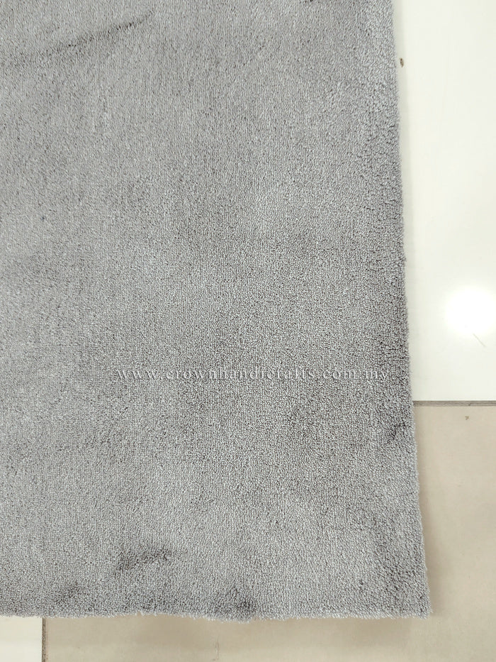 Grey floor rug with fine, speckled texture and smooth short pile.