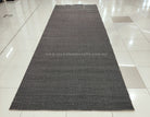 Dark grey extra-long area rug with subtle geometric woven pattern and textured surface