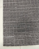 Dark grey area rug close-up showing repeating grid-like textured pattern