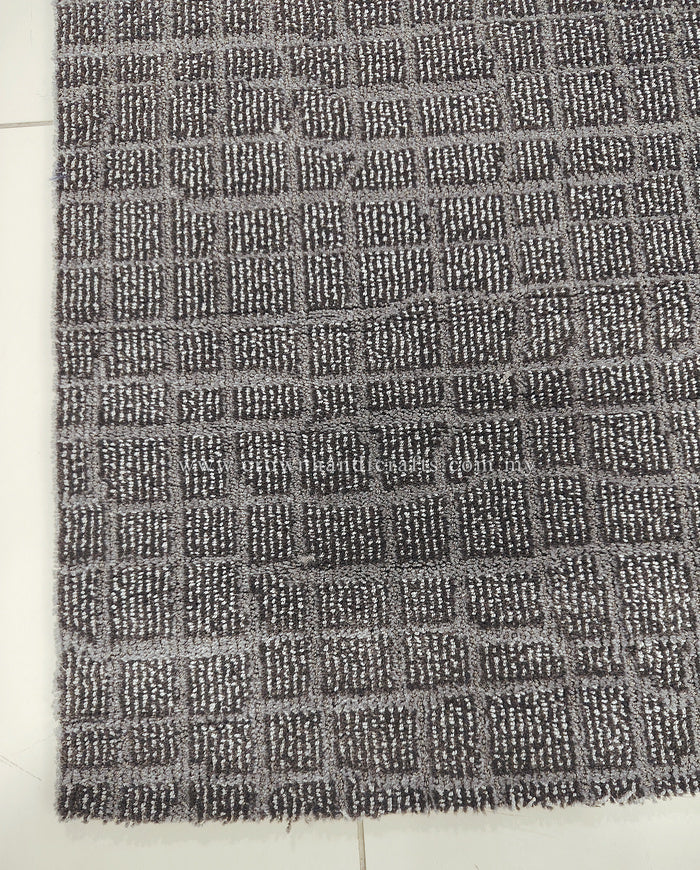 Dark grey area rug close-up showing repeating grid-like textured pattern