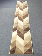 Narrow runner rug with bold chevron pattern in bone, beige and dark brown tones.